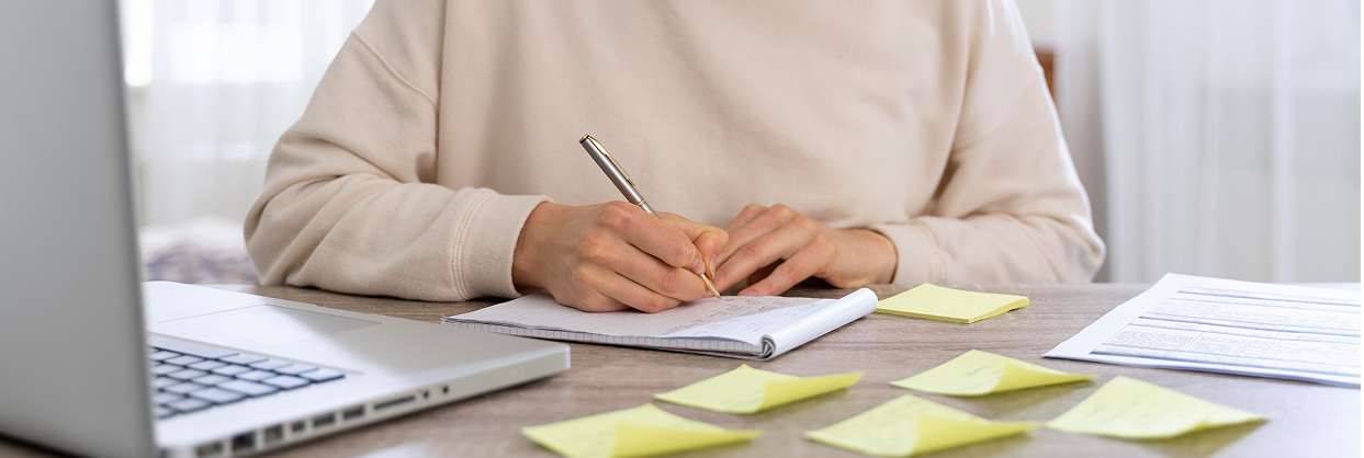 Rebecca Roby - Woman writing at a desk, reflecting on her diagnosis, treatment, and recovery experience.