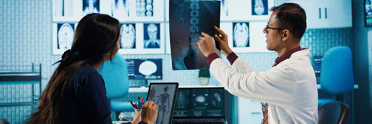 Rebecca Roby - Physician reviewing medical imaging with a patient as part of pancreatic tumor diagnosis and treatment planning.